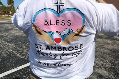 A member of BLESS Ministry for Life at St. Ambrose Parish in Deerfield Beach shows off the ministry's new T-shirt for members.