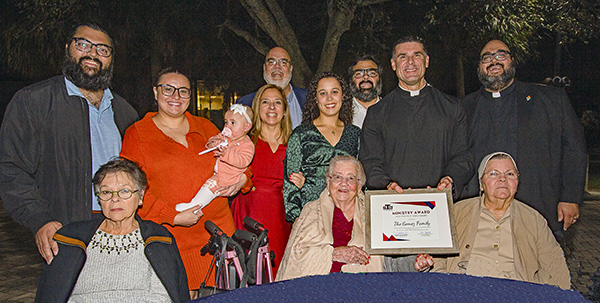 La Familia Gómez recibe el Premio Familia Apostólica de manos del P. Rafael Capó, vicepresidente de Misión de la Universidad St. Thomas. Fue uno de los 10 reconocimientos entregados durante la cena y celebración inaugural de los Premios al Ministerio de la universidad, celebrada el 29 de noviembre de 2023 en el campus de Miami Gardens.