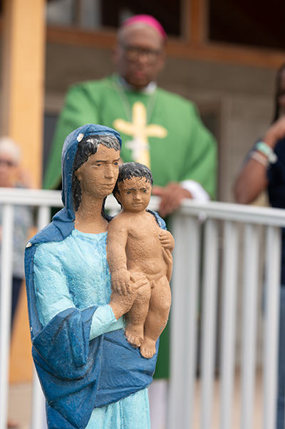 Archbishop Patrick C. Pinder of Nassau, Bahamas, looks at a statue of Mary with the Christ Child outside the newly rebuilt and dedicated Sts. Mary and Andrew Church in Treasure Cay, Abaco, after celebrating Mass for the Miami archdiocesan delegation that visited at the end of November. The old church was completely destroyed during by Category 5 Hurricane Dorian in 2019.