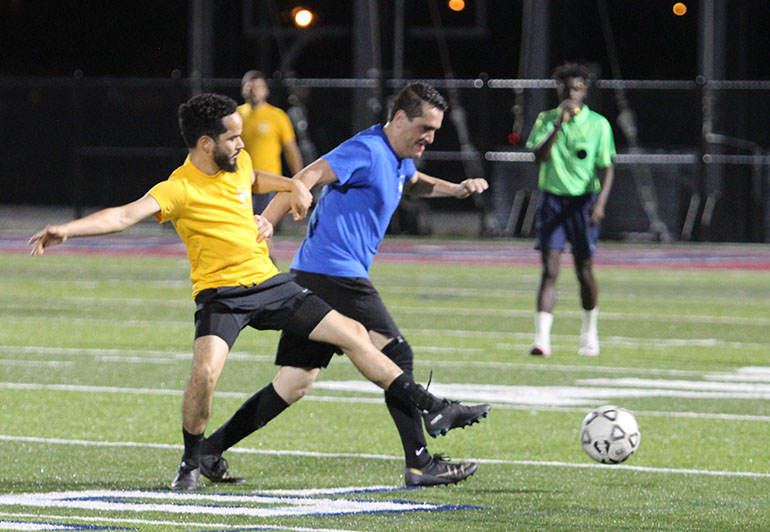 Father Juan Carlos Salazar (blue), administrator of St. Martha Parish in Miami Shores, fights for the ball with seminarian and then-Deacon Saul Araujo, who was ordained a priest a few months after the game in 2023. The second annual Archbishop's Cup soccer game will be played Friday, Jan. 26, 2024, once again on the field at St. Thomas University, Miami Gardens.