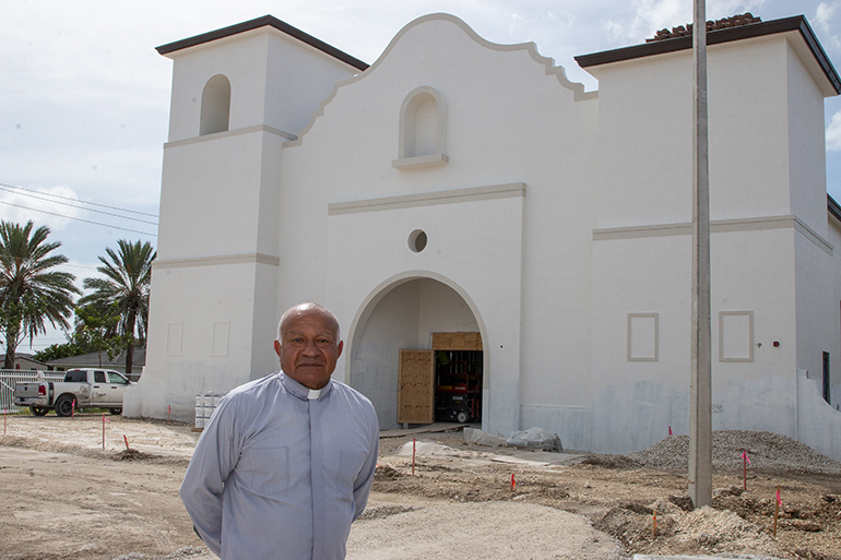 El P. Rafael Cos, administrador de la misión Santa Ana, posa frente a la construcción del nuevo edificio de la misión en Naranja, el 12 de octubre de 2023. Se espera que la construcción finalice en marzo de 2024. El edificio tiene la forma de una misión californiana.