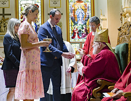 Close family members of the Miami Catholic Lawyers Guild 2023 Lex Christi, Lex Amoris honoree, Judge John J. O'Sullivan, take up the offertory at the Dec. 11 Mass celebrated at Gesu Church in Miami. From left: Cathy McKenna, wife (rear), Kelly O'Sullivan McKenna, daughter, and Thomas McKenna, son-in-law.