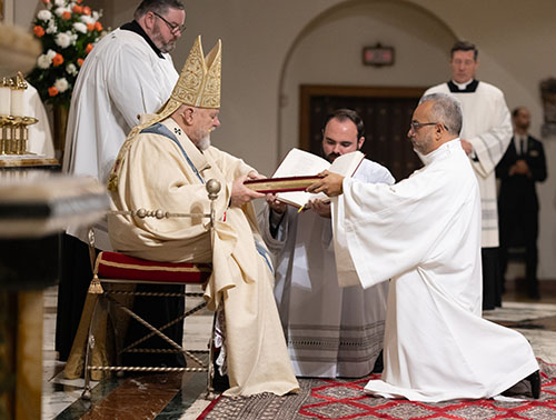 Archbishop Thomas Wenski presents Deacon Jorge Escobar with the Book of the Gospels, "whose herald you have become," Dec. 16, 2023, at St. Mary Cathedral.