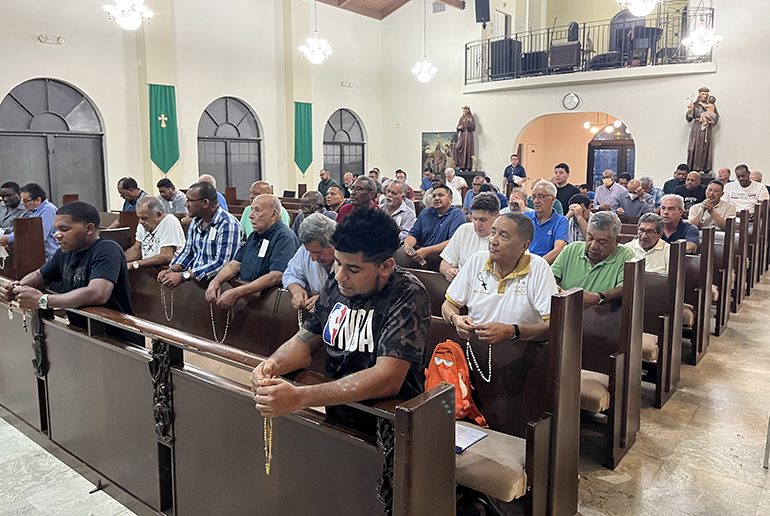 Hombres rezando el rosario por la paz en la misión San Francisco y Santa Clara de la iglesia Corpus Christi de Miami, el 28 de septiembre de 2023.