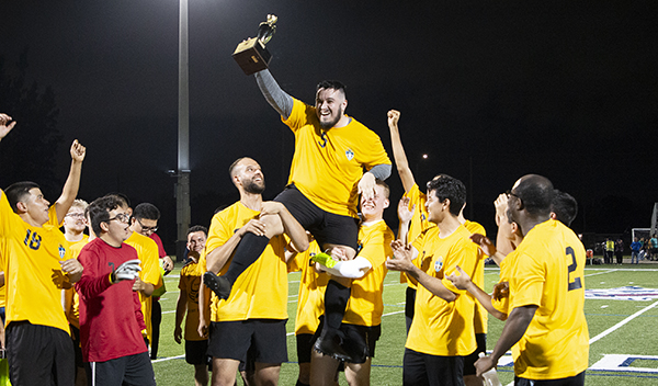 Seminarian and team captain Gabriel Campos is hoisted by teammates after his team's 3-0 win over the priests at the second annual Archbishop's Cup soccer game, played Jan. 26, 2024, on the field of St. Thomas University, Miami Gardens.