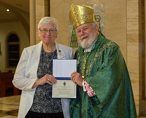 Archbishop Thomas Wenski gives Adrian Dominican Sister Mary Frances Fleischaker a certificate of appreciation to mark her 50 years of religious profession during the annual Mass for the World Day of Prayer for Consecrated Life, celebrated Feb. 3, 2024, at St. Mary Cathedral, Miami.
