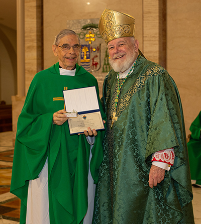 Archbishop Thomas Wenski gives Jesuit Father Javier Lopez a certificate of appreciation to mark his 60 years of religious profession during the annual Mass for the World Day of Prayer for Consecrated Life, celebrated Feb. 3, 2024, at St. Mary Cathedral, Miami.