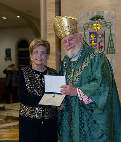 Archbishop Thomas Wenski gives Adrian Dominican Sister Evelyn Piche a certificate of appreciation to mark her 70 years of religious profession during the annual Mass for the World Day of Prayer for Consecrated Life, celebrated Feb. 3, 2024, at St. Mary Cathedral, Miami.