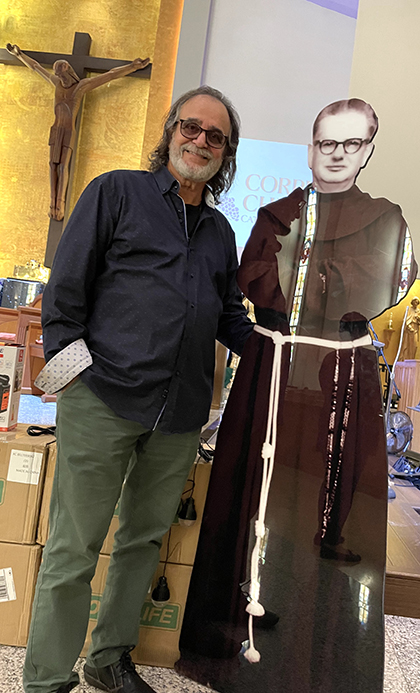 Adalberto Socas, president of the organization The Children of Father Camiñas, next to a large photograph of the Franciscan friar Antonio Camiñas, after Mass at Corpus Christi Parish, in Miami, March 10, 2024.