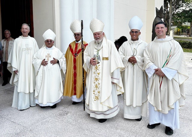 From left are Father Patrick O'Neill, former president of St. Thomas University in Miami (STU); Bishop Enrique Delgado, Auxiliary Bishop of Miami; Cardinal Juan de la Caridad García, Archbishop of Havana; Miami Archbishop Thomas Wenski; Bishop Eloy Ricardo Domínguez Martínez, Auxiliary Bishop of Havana; and Father Rafael Capo, vice president for Mission at STU, as they pose for a photo in front of the reconstructed chapel of the former St. Thomas de Villanueva University in Havana, April 24, 2024.