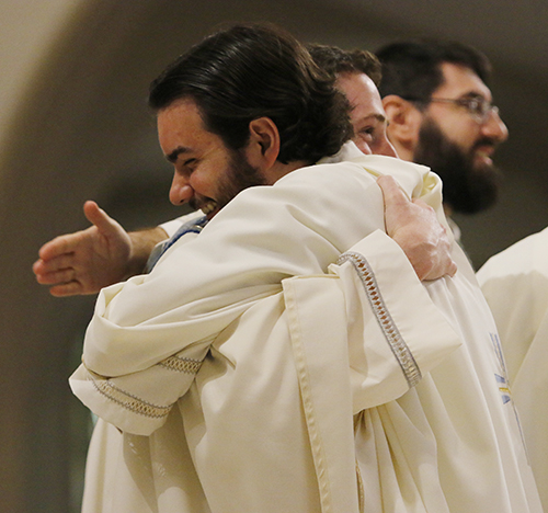 Father Andrew Vitrano-Farinato, ordained last year, smiles as he embraces newly ordained Father John Buonocore after the ordination rite, May 11, 2024, at St. Mary Cathedral in Miami. On that date, Archbishop Thomas Wenski ordained four men to the priesthood.