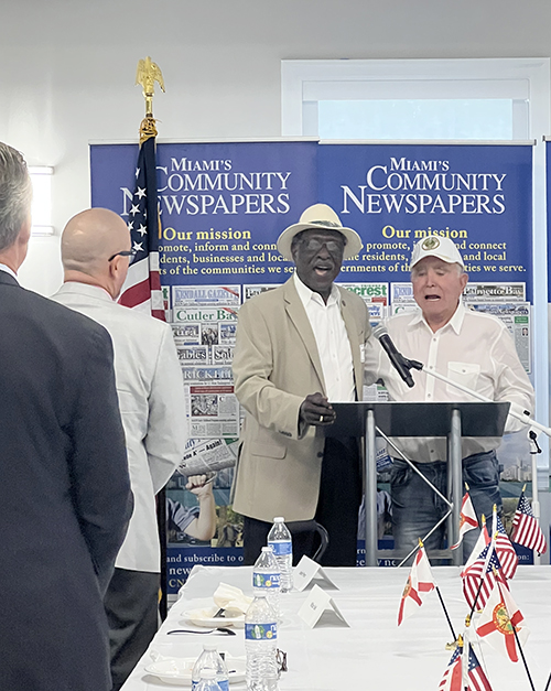 Wilbur B. Bell and Mike Carricarte lead the Pledge of Allegiance and the singing of “God Bless America” at the Miami’s Community News Pinecrest Luncheon with Archbishop Thomas Wenski, May 15, 2024, in Pinecrest. Miami’s Community Newspapers organize luncheons monthly, a gathering of locals and Miami leaders such as Archbishop Wenski, who spoke at this month’s event.