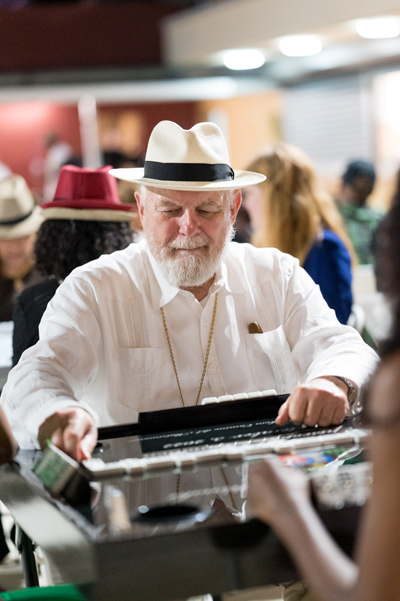 Archbishop Thomas Wenski makes a move during a game of dominos at the annual Havana Nights fundraiser for Catholic Charities' Unaccompanied Minors Program. The event took place May 3, 2024, 
in the courtyard in front of the Chapel of Our Lady of La Merced, at Corpus Christi Church in Miami.