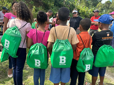 Children from La Pieza, Dominican Republic, wear their new St. Brendan High School drawstring bags given to them as gifts by a group from St. Brendan's who participated in a BLUE Missions trip to their community.