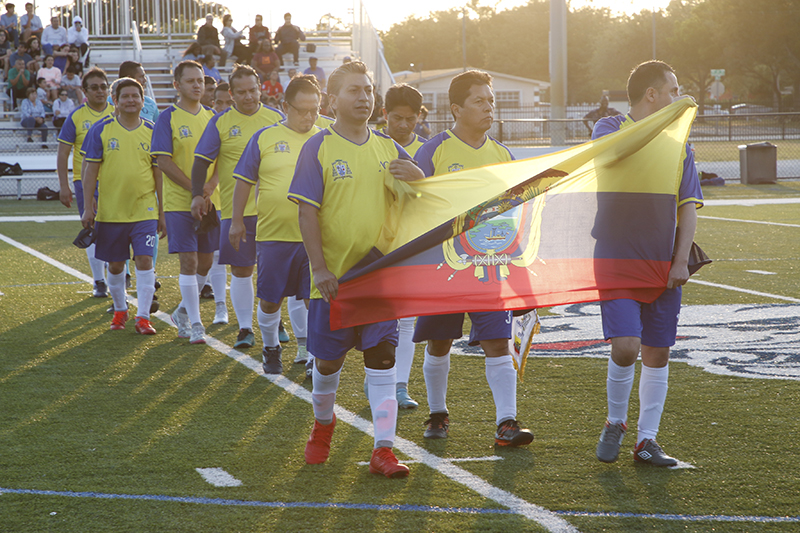 Priests of the Archdiocese of Quito, Ecuador enter the field with their flag during the presentation of the teams at the Clericus Cup International soccer match between priests of the Archdiocese of Miami and priests from the Archdiocese of Quito, Ecuador. The game was played April 23, 2024 on the soccer field at St. Thomas University in Miami Gardens.