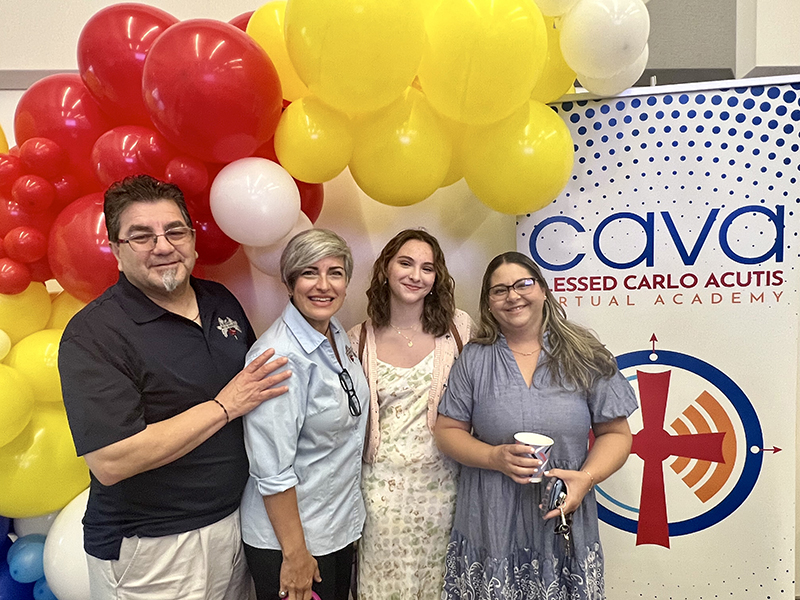 From left to right: Fernando Vega, member of the ARCH Angels of South Florida homeschool group board of directors; Diana Vega, previous vice president of the ARCH Angels; Isabella Vazquez, a rising 12th grader at Blessed Carlo Acutis Virtual Academy (CAVA); and her mother, Yakelin Vazquez, pose with the CAVA school banner at the CAVA Inaugural Mass and Blessing Ceremony May 29, 2024, at St. Brendan High School in Miami.