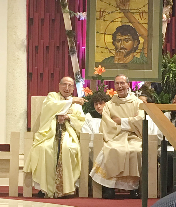 In this photo from about two years ago, during a Eucharistic celebration at St. Matthew Parish in Hallandale Beach, Father Julio Estada (left) points to Father Jose Luis Paniagua, with whom he served at St. Benedict Parish in Hialeah in the 1980s.