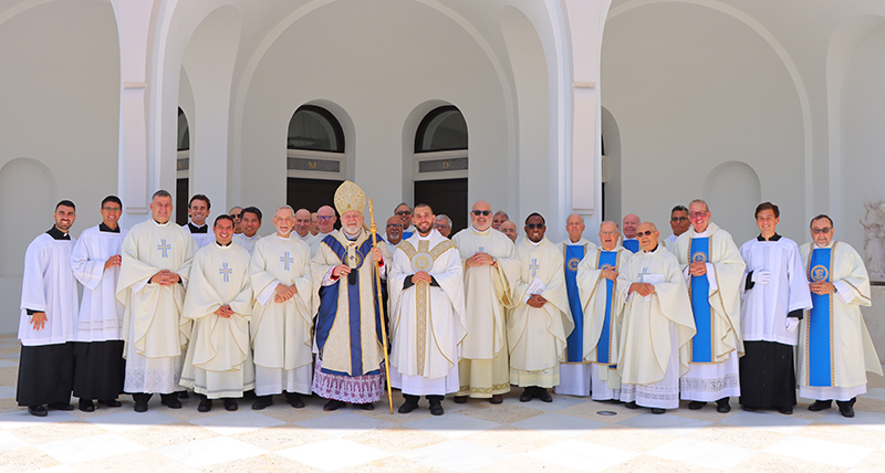After the Mass, newly ordained Jesuit Father Michael Anthony Martínez poses with Archbishop Thomas Wenski, Jesuits, and priests from the Archdiocese of Miami at the main entrance to Our Lady of Belen Chapel in Miami, June 1, 2024.