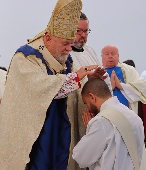 Archbishop Wenski lays hands on Deacon Michael Anthony Martínez, invoking the Holy Spirit and ordaining him a priest for the Jesuit Order, June 1, 2024, at Our Lady of Belen Chapel in Miami.