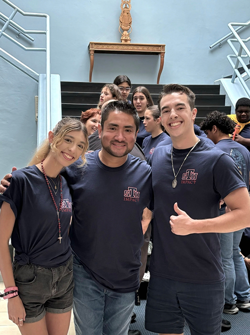 Ivan Diaz, director of campus ministry at St. Thomas University (center), poses with STU Impact camp counselors Valerie Richard and Camilo Gomez, who, along with other young adult leaders, guided 54 students from Catholic and public high schools in this year's summer camp.