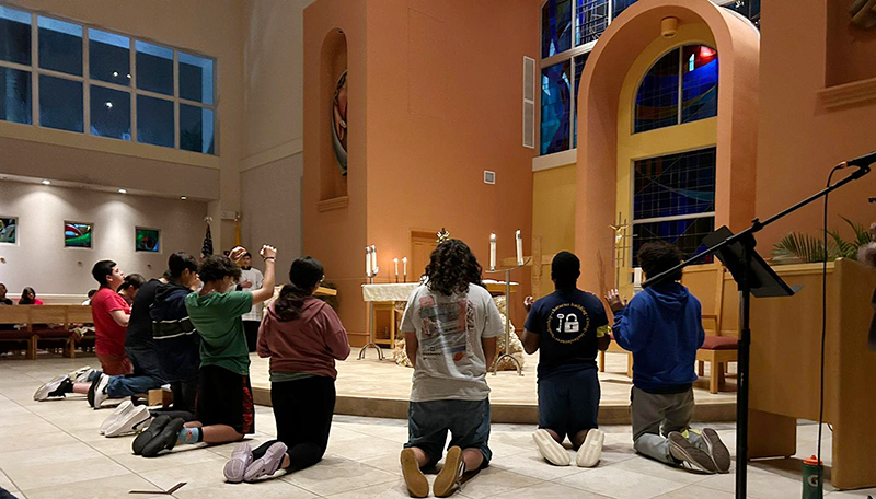 A moment of group adoration is shared at STU Impact summer camp. A total of 54 students from Catholic and public high schools participated in this year's camp focusing on fellowship and formation in the faith.
