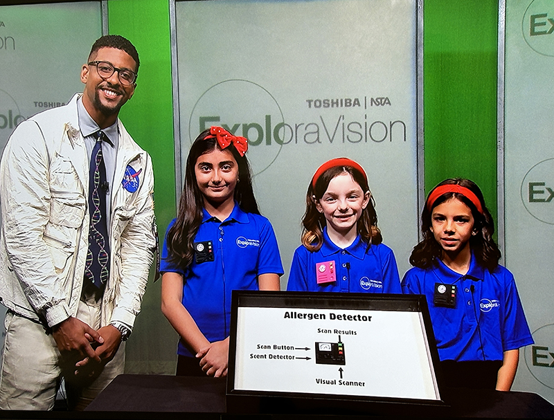 Isabella Gustin, second from left, Adriana Icaza and Emilia Martinez Christensen, third graders from St. Thomas the Apostle School in Miami, pose June 14, 2024, with Justin “Mr. Fascinate” Shaifer during a media presentation of their invention, the Allergen Detector.