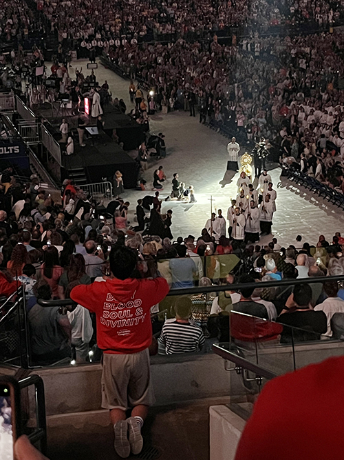 A teen boy kneels reverently during the Eucharistic adoration that took place on July 19, 2024 at the Lucas Oil Stadium during the National Eucharistic Congress.