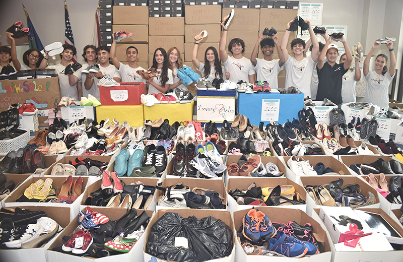 Volunteers with Loving Soles, a student-run charity, show off some of the thousands of shoes they’ve collected for the Camillus House homeless shelter. The collection was held May 6, 2024, in Miami Lakes.