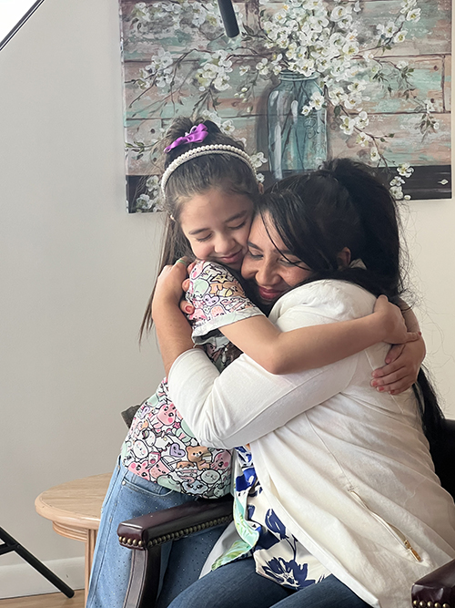 Luz Alvarado and her daughter Genesis embrace during filming at Respect Life’s Central Broward Pregnancy Center in Fort Lauderdale Friday, July 19, 2024. Luz shared her story about how pregnancy help center support empowered her and her husband to raise their daughter.