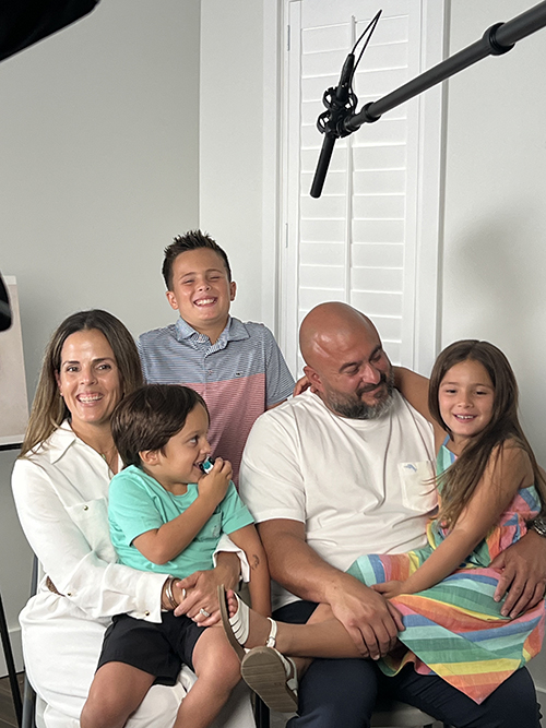 Christie Acosta and her husband John Mora are filmed with their children Myles (first row), Cruz (second row, middle), and Liv (second row, far right) Sunday, July 28, 2024. The couple shared the story of their daughter Vida Elyse, who had Trisomy 13 and who had a short life, and they talked about the gifts her life brought to their family and community.