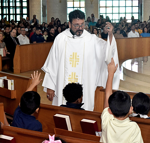 Father Jaime Acevedo, pastor of St. Mark Church speaks to students during a Mass Sept. 11, 2024, just before the announcement that the church school has been recognized as an Apple Distinguished School.