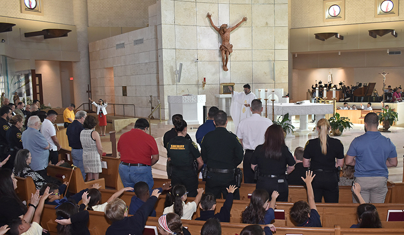 Students of St. Mark School pray for first responders during Patriot’s Day Mass Sept. 11, 2024, just before the announcement that their school has been recognized as an Apple Distinguished School.