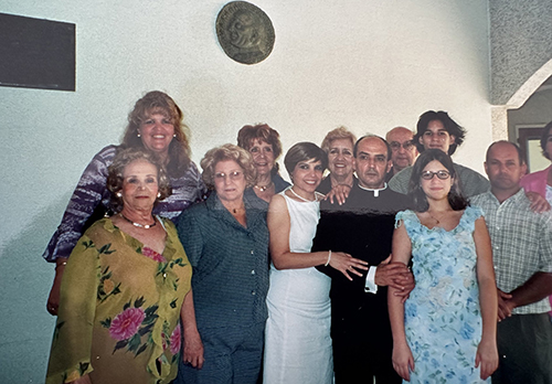 Father Jorge Bello poses with several family members after his ordination May 10, 2023.