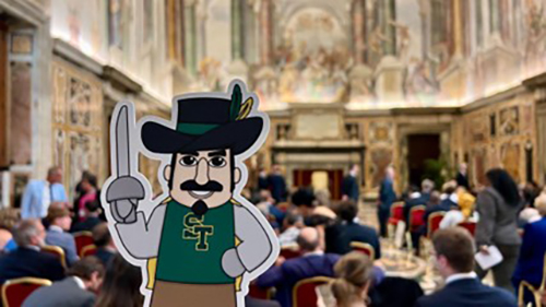 A cut out of Louis the Musketeer, the mascot of St. Theresa Catholic School in Coral Gables, is held up in Clementine Hall in the Apostolic Palace in Vatican City. The cut-out was gifted to Pope Francis by Coral Gables Commissioner Kirk Menendez and his wife Maria Teresa during a conference held at the Vatican in August 2024.