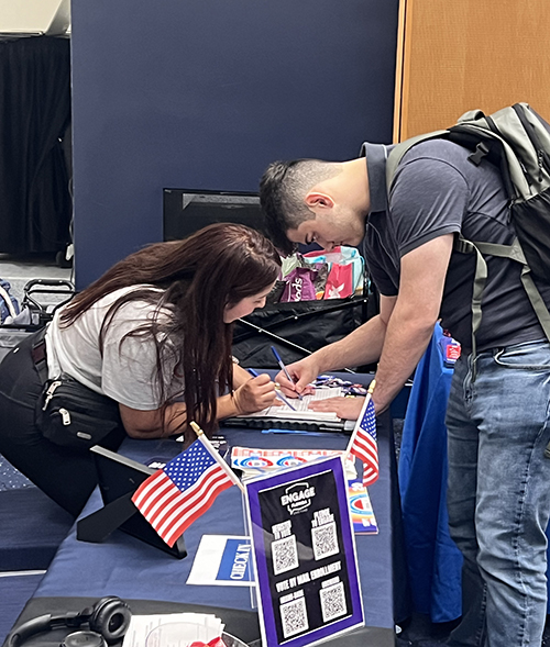 UnidosUS representative Hidana Lopez helps a student fill out a voter registration form during the National Voter Registration Day event Sept. 17, 2024 at the Florida International University Graham Center in Miami.