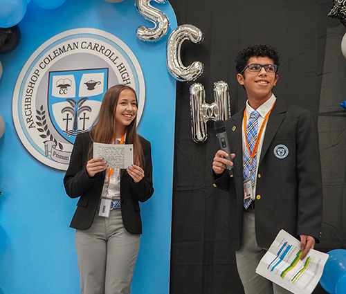 Nelly Finkbeiner (left) and Johandry Escobar, Archbishop Coleman Carroll High School students participating in the St. Michael's Scholars Program, speak during the program's induction ceremony Oct. 24, 2024, in the school's gymnasium.