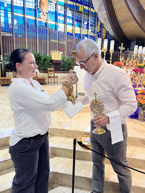 Volunteers, Maria Camposano (left) of Epiphany Parish in Miami and Thomas Ranney of St. Hugh Church in Coconut Grove pause to venerate the sacred relic of St. Augustine during the Sacred Relics Exposition and Veneration at St. Hugh Nov. 3, 2024.