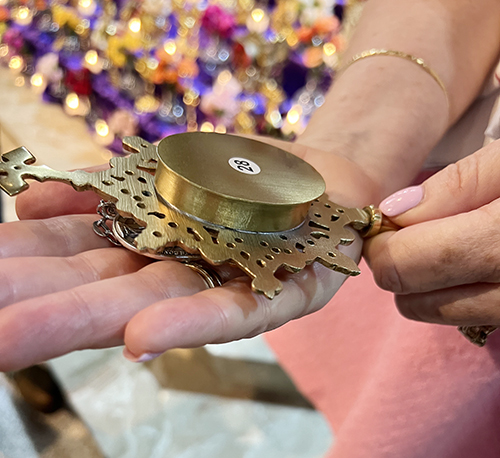 During the Sacred Relics Exposition and Veneration at St. Hugh Parish Nov. 3, 2024, a member of the faithful touches her miraculous medals to the first-class relic of the True Cross, making the medals third-class relics.