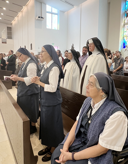 Daughters of St. Paul (from left) Sister Mary Sophie Stewart, Sister María Elizabeth Borobia, and Sister Teresa Meza pray with Carmelite Sisters of the Most Sacred Heart of Los Angeles during Mass celebrating the Daughters of St. Paul’s 65-year anniversary in Miami. The Mass and reception took place Nov. 3, 2024 at Our Lady of Guadalupe Parish in Doral.