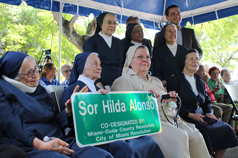 Sister Olga Gomez (in beige), who served in Cuba, Puerto Rico and Miami, died Nov. 8, 2024. She was 77 years old. She attended the recent street naming ceremony Sept. 9 in honor of Sister Hilda Alonso, founder of the Daughters of Charity of St. Vincent de Paul of Miami. From left, bottom row, Sister Clemencia Fernandez, Sister Rafaela Gonzalez, Sister Olga Gomez and Sister Reynalda Ramirez. Standing, from left, Sister Milagros Olivencia, Sister Juanita Flores, Commissioner Miguel Angel Gabela, Miami-Dade County Community Council Board Member Dariel Fernandez and Sister Eva Perez-Puelles.