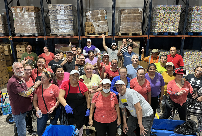 Volunteers and staff of Catholic Charities Matthew 25 Food Pantry in Miami pose for a group photo at the warehouse where they distribute food and other goods to over 1,500 households on the first and third Saturdays of each month.