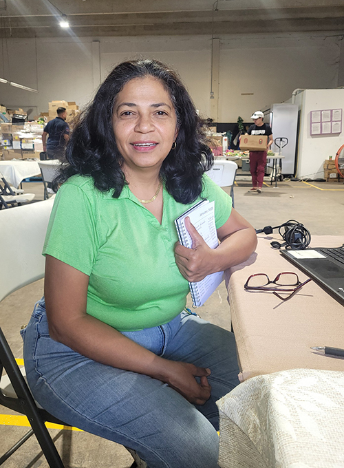 Aracelis Avila takes a break while volunteering at Catholic Charities Matthew 25 Food Pantry in Miami. Avila and her family first came to the pantry in March 2020, when they distributed food drive-thru style during the pandemic. Moved by their work and the needs of the community, Avila and her family began volunteering at the pantry.