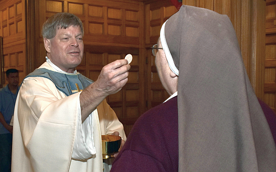 Father Steven O'Hala serves Holy Communion during the Jubilee Mass Dec. 28, 2024, at St. Mary Cathedral in Miami