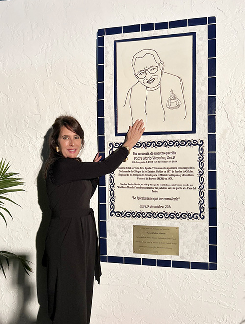 Patricia Reyes Vizcaíno, the niece of Father Mario Vizcaíno, poses in front of the plaque dedicated to her uncle, the founder of SEPI, the Southeast Pastoral Institute of Hispanic Ministry Dec. 4 at SEPI.