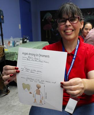 Veronica Curbelo shows the plans for her "Music Angel" ornament, which was inspired by her love for music. Curbelo, and other clients of the Marian Center's Adult Day Training Program, will create the ornaments for this year's Christmas ornament project.