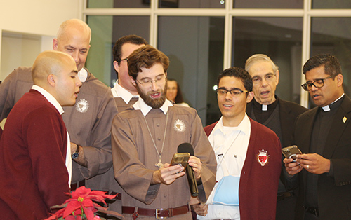 From left, Servants of the Pierced Hearts brothers and priests (in maroon and brown); Jesuit Father Javier Lopez, of Gesu Parish in Miami (second from right); and Father Milton Martinez, Archdiocese of Miami vocations director, sing “Silent Night” in English, German and Spanish during the Serra Club of Miami’s Christmas Dinner for Religious Sunday, Dec. 8. The annual event, hosted at St. John Vianney College Seminary and organized by the Serra Club lay organization for vocations, celebrates local religious from around South Florida.