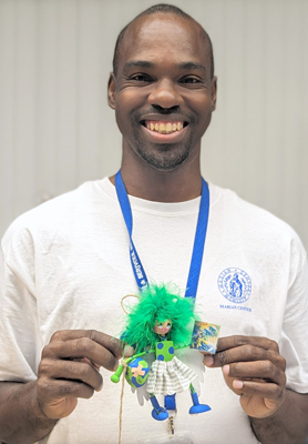 Steve Williams poses with the planet Earth angel ornament he designed at the Marian Center this holiday season.