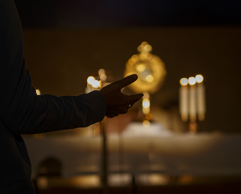 An attendee reaches out to the monstrance during Eucharistic Adoration at St. Louis Parish in Pinecrest Aug. 5, 2024.