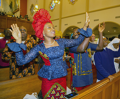 Ebele Ekweanya dances to the beat of drummer after the annual Migration Mass celebrated by Archbishop Thomas Wenski Jan. 5, 2025, feast of the Epiphany, at St. Mary Cathedral of Miami.