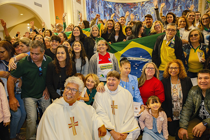 Brazilian-American Apostolate members pose for a group photo with Father Jesus "Jets" Medina (seated left), pastor of St. Peter the Fisherman Church in Big Pine Key, and archdiocesan director of Cultural Groups and with Brazilian Father Adelson Moreira, parochial vicar of Corpus Christi Parish in Miami, after the annual Migration Mass, celebrated by Archbishop Thomas Wenski Jan. 5, 2025, feast of the Epiphany, at St. Mary Cathedral.